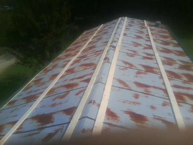 Rusted metal roof panels with new wood purlins before replacement — Storm Damage Roof Repair in Douglasville by Roofing Brothers