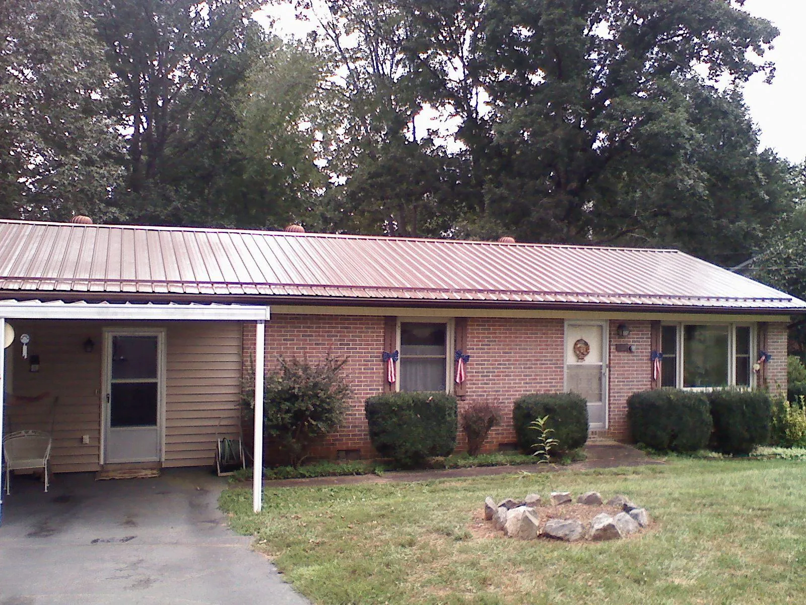 Bronze metal roof and carport on a brick ranch home — Roof Repair work by our crew in Douglasville