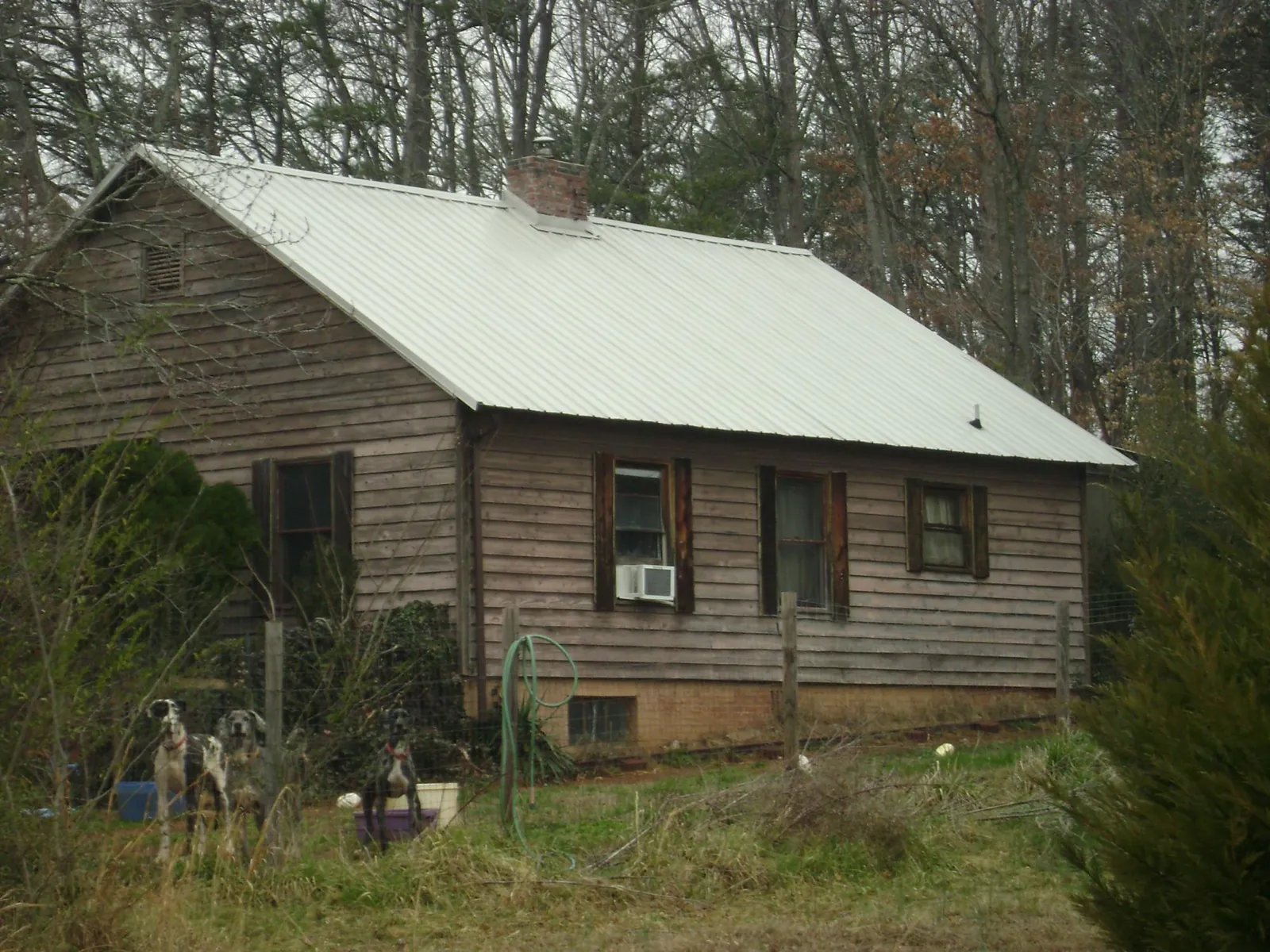 White metal roof on an old wood sided farmhouse, from a Metal Roof Installation job in Douglasville